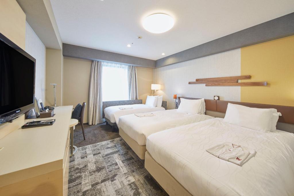 Richmond Hotel Narita 객실 내부: 두 침대·창가 책상·실내 통로