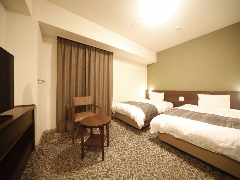 Two beds, a wood headboard and olive wall