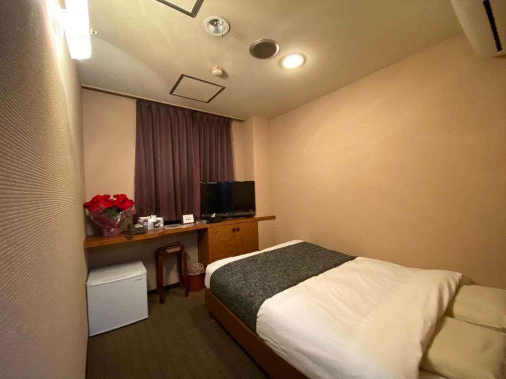A bed, dark curtains and TV desk