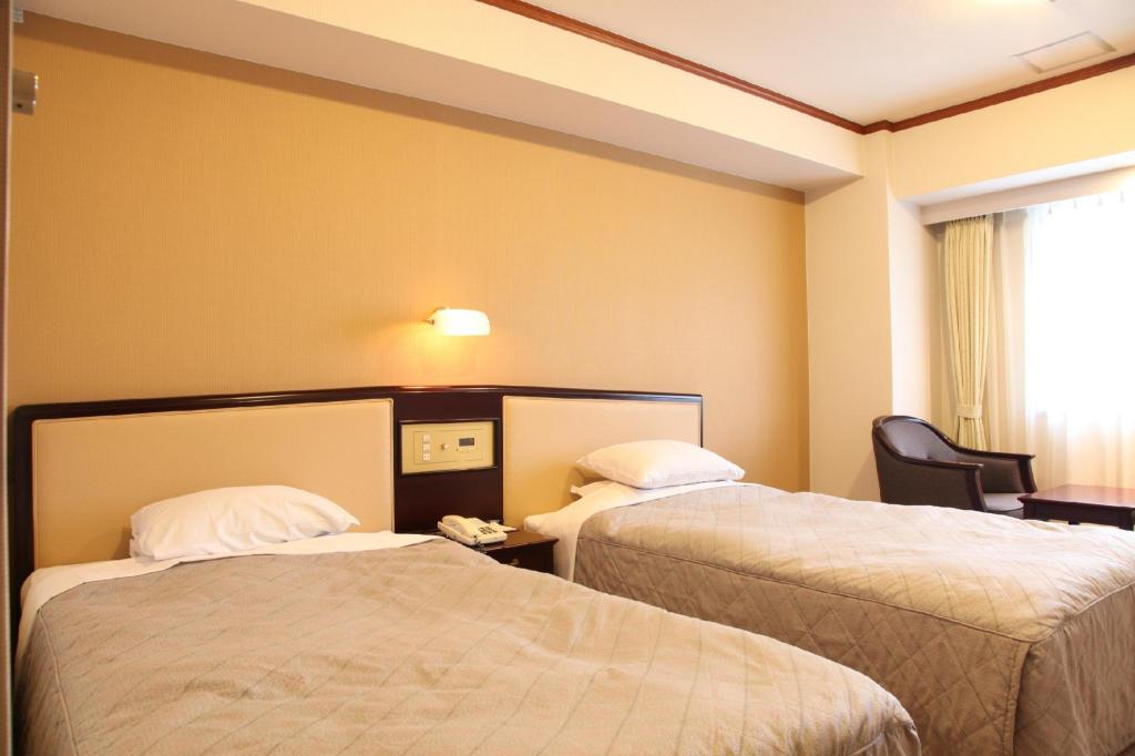 Cream-panel headboards, twin beds and armchairs by the window
