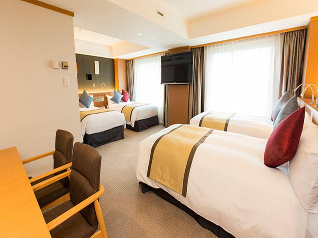 Narita Tobu Hotel Airport 객실 내부: 침대 세 개와 책상·창가 공간