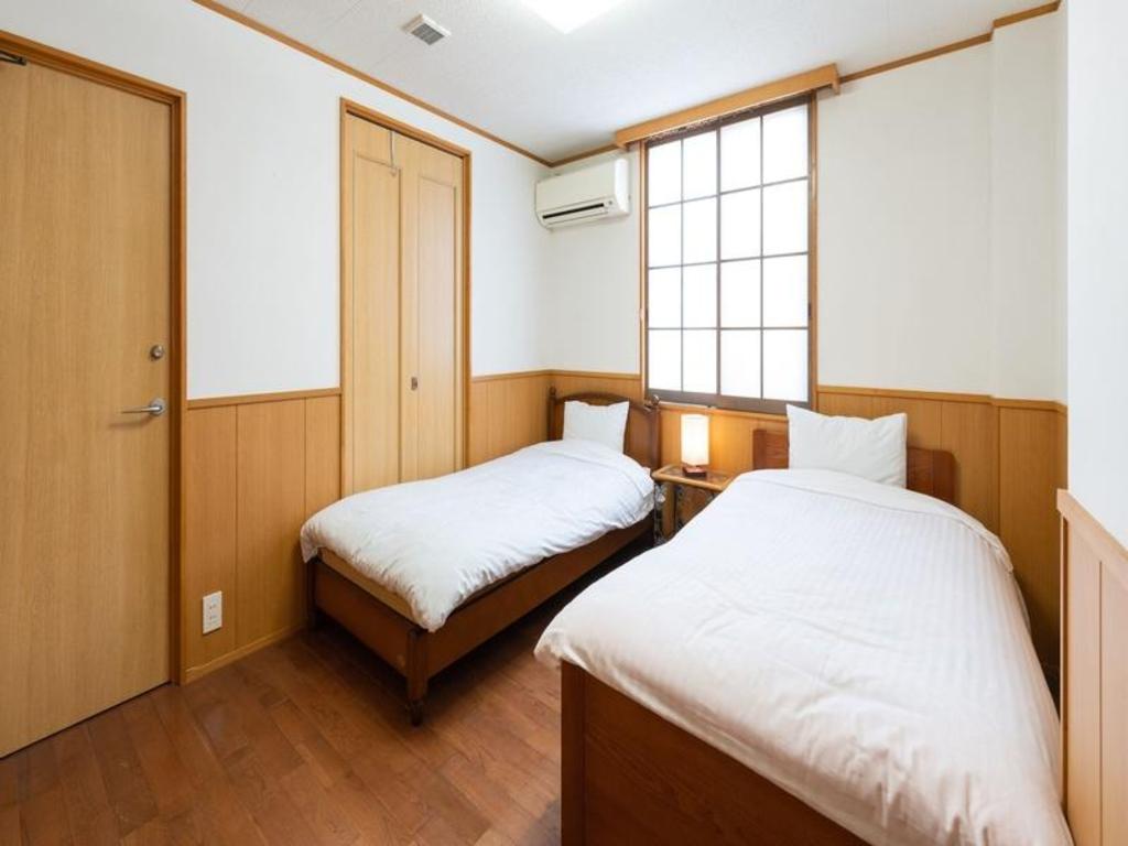 Wood walls and floor, a shoji window and two beds