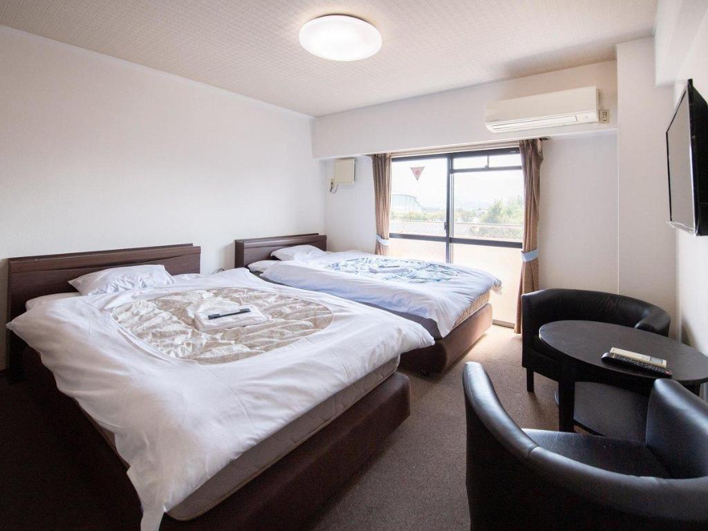 Two beds, a round table and black chairs