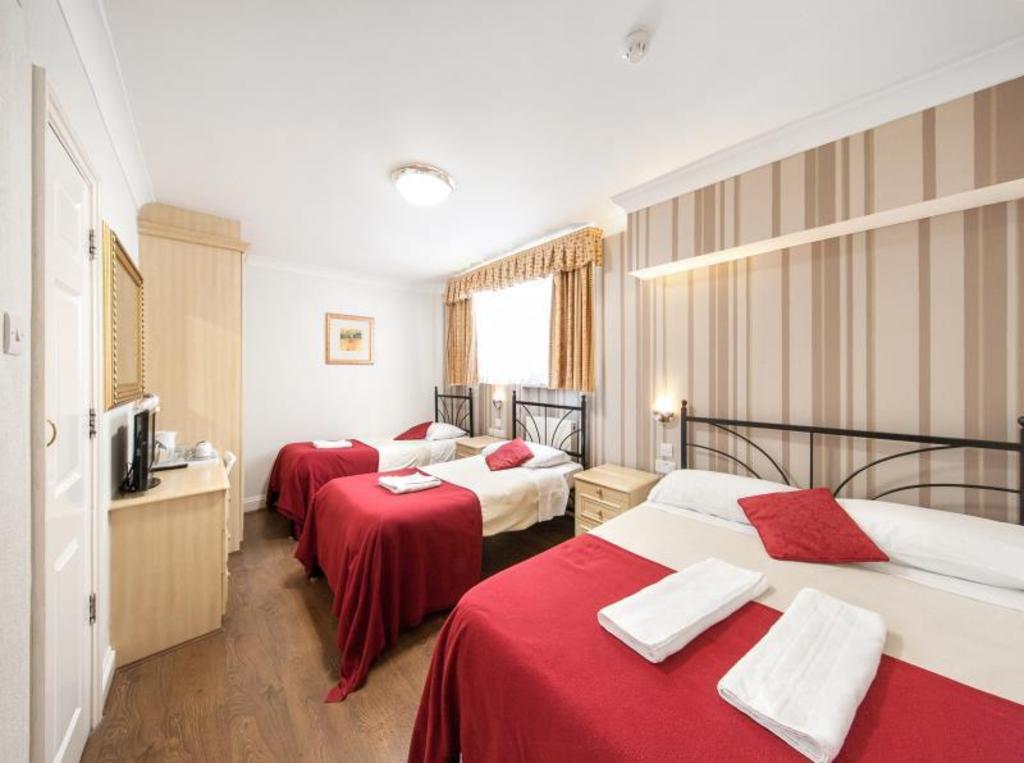 Fairway Hotel 여러 침대·수건·옷장이 보이는 객실 내부 예시