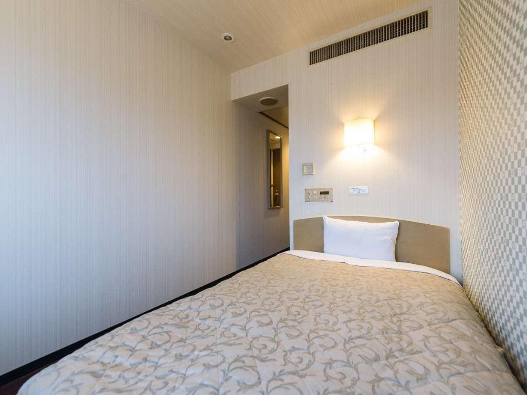 A patterned wall, bed and entrance door