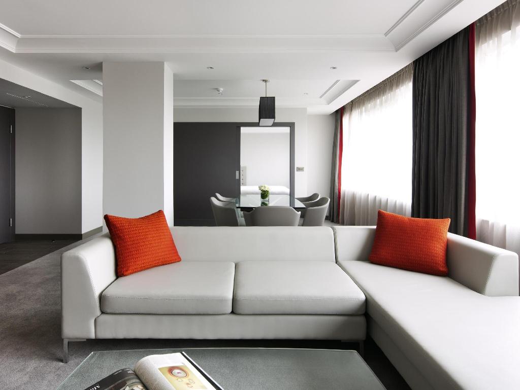Pullman London St Pancras 소파·테이블과 침실로 이어지는 실내 생활 공간 예시