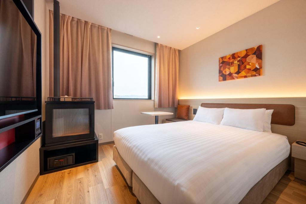 Orange geometric artwork, double bed and round table