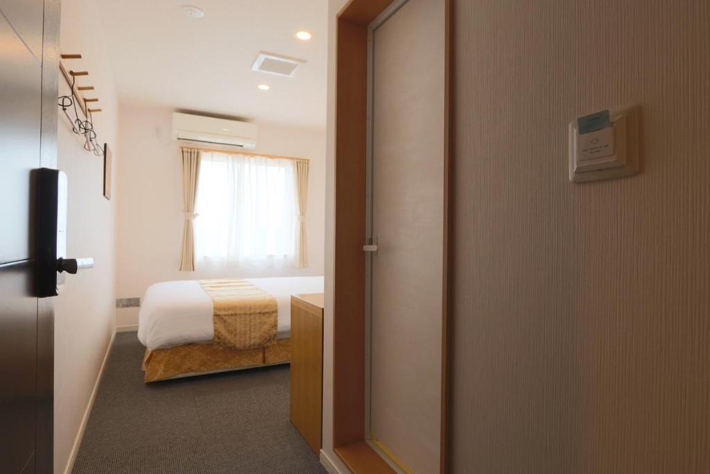 A window-side bed, TV and room entrance