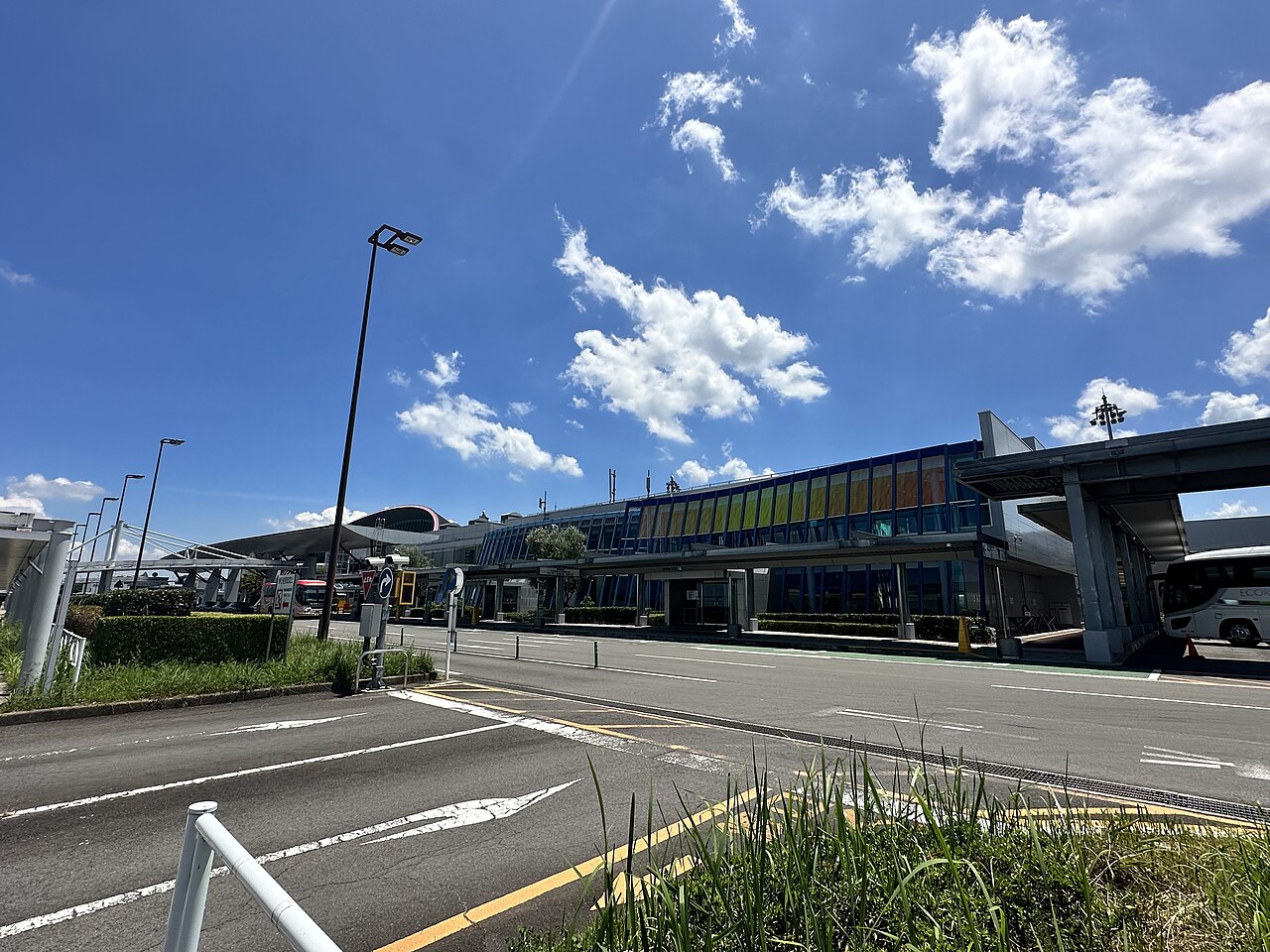 Takamatsu Airport terminal behind the road and lamp posts under a blue sky