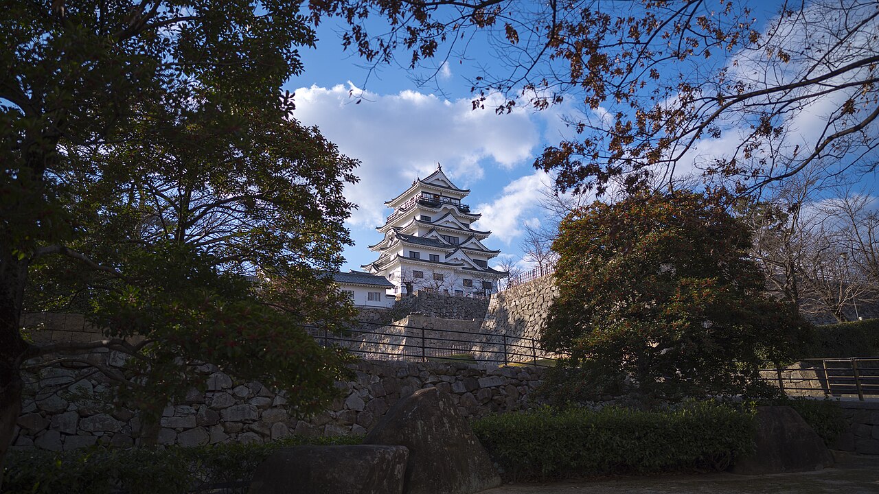 Fukuyama Castle keep above stone walls, framed by trees
