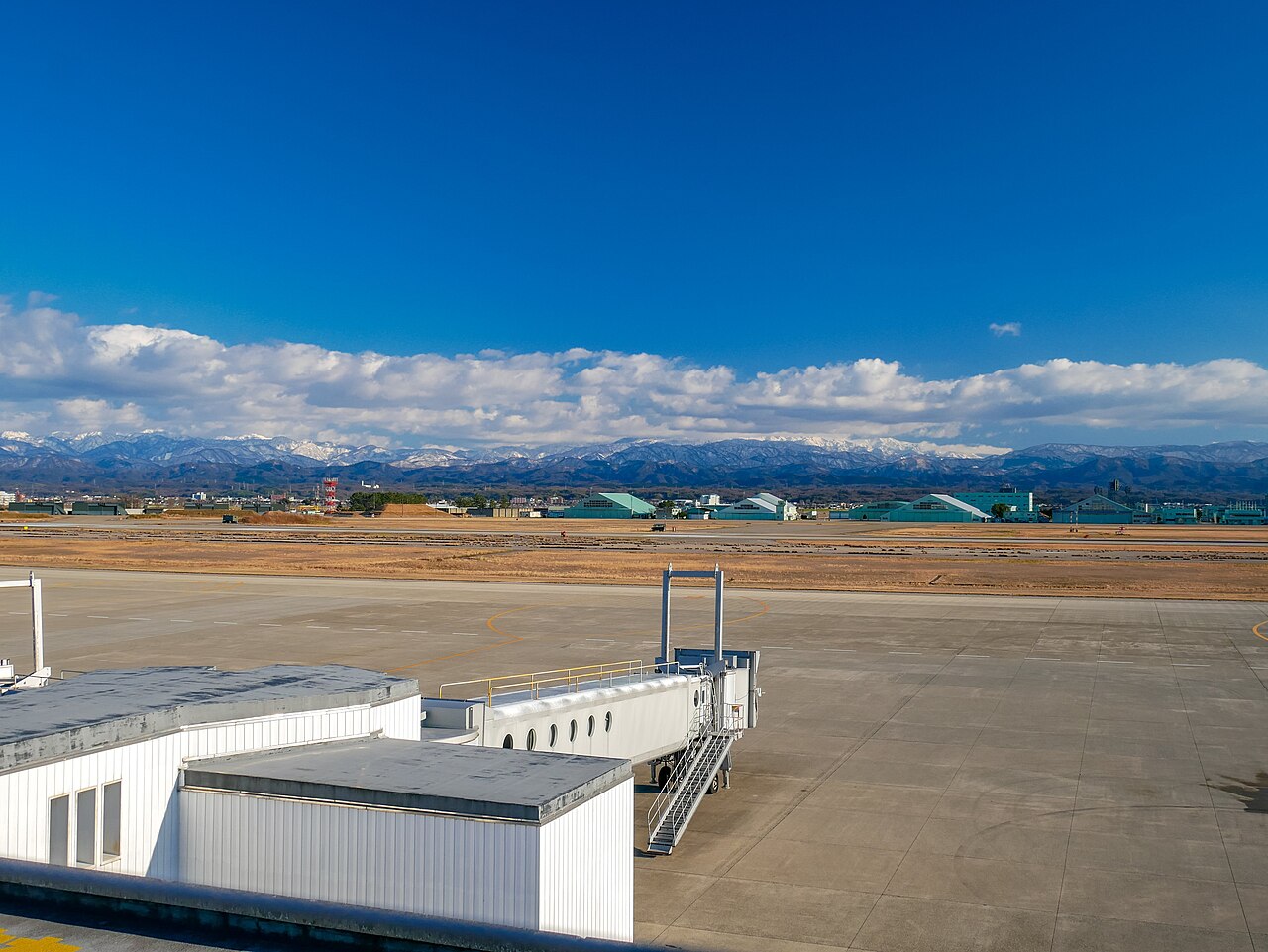 고마쓰 공항 계류장과 탑승교 너머 산 풍경