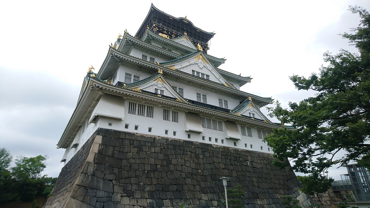 Low-angle view of Osaka Castle keep above its stone base