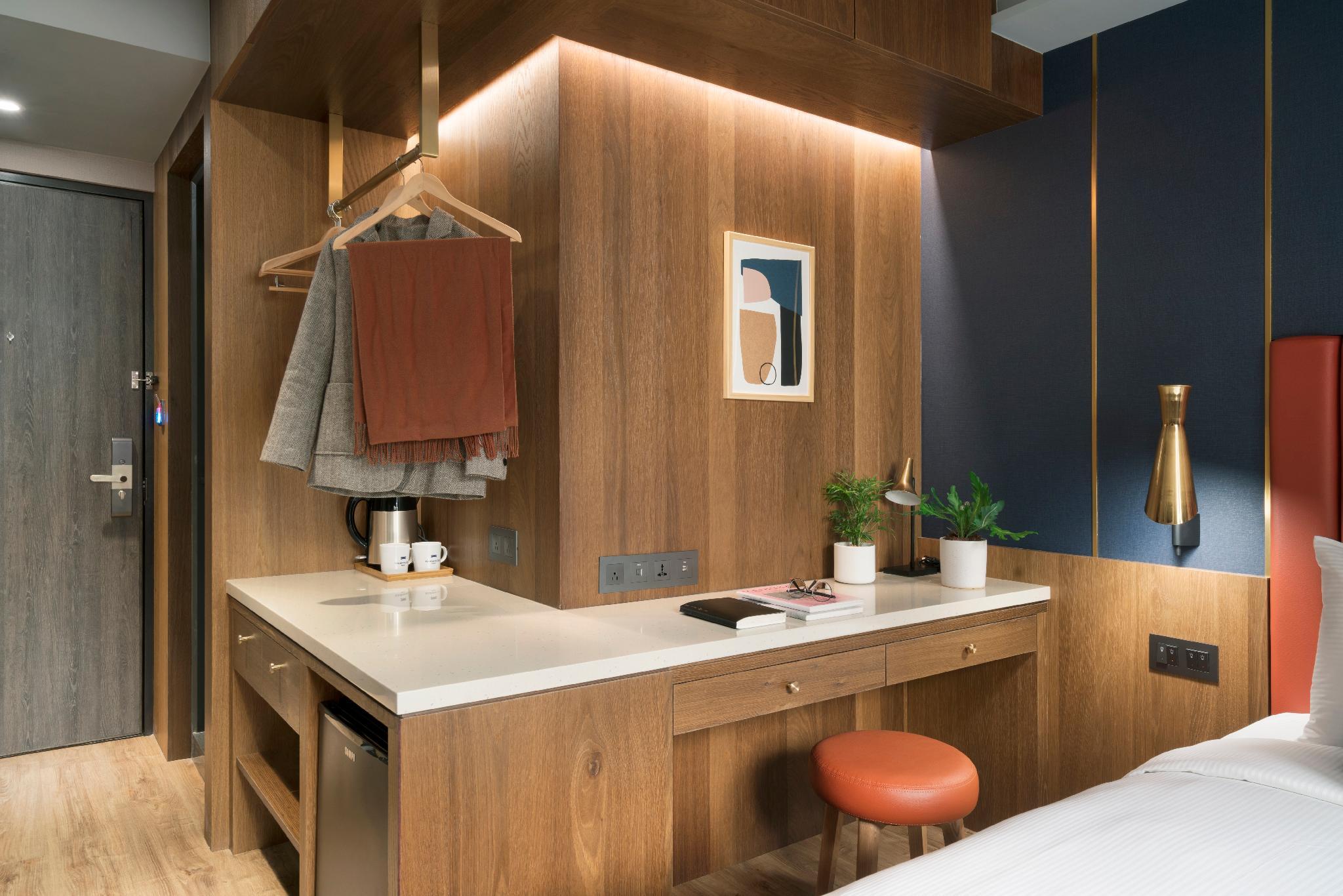 Kindness Day Hotel: Guestroom interior showing a desk, hanger and edge of the bed