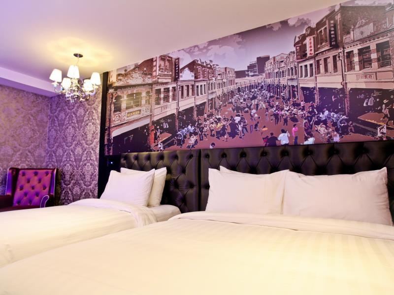 FX Hotel Tainan: Guestroom with a large bed, smaller bed and street mural