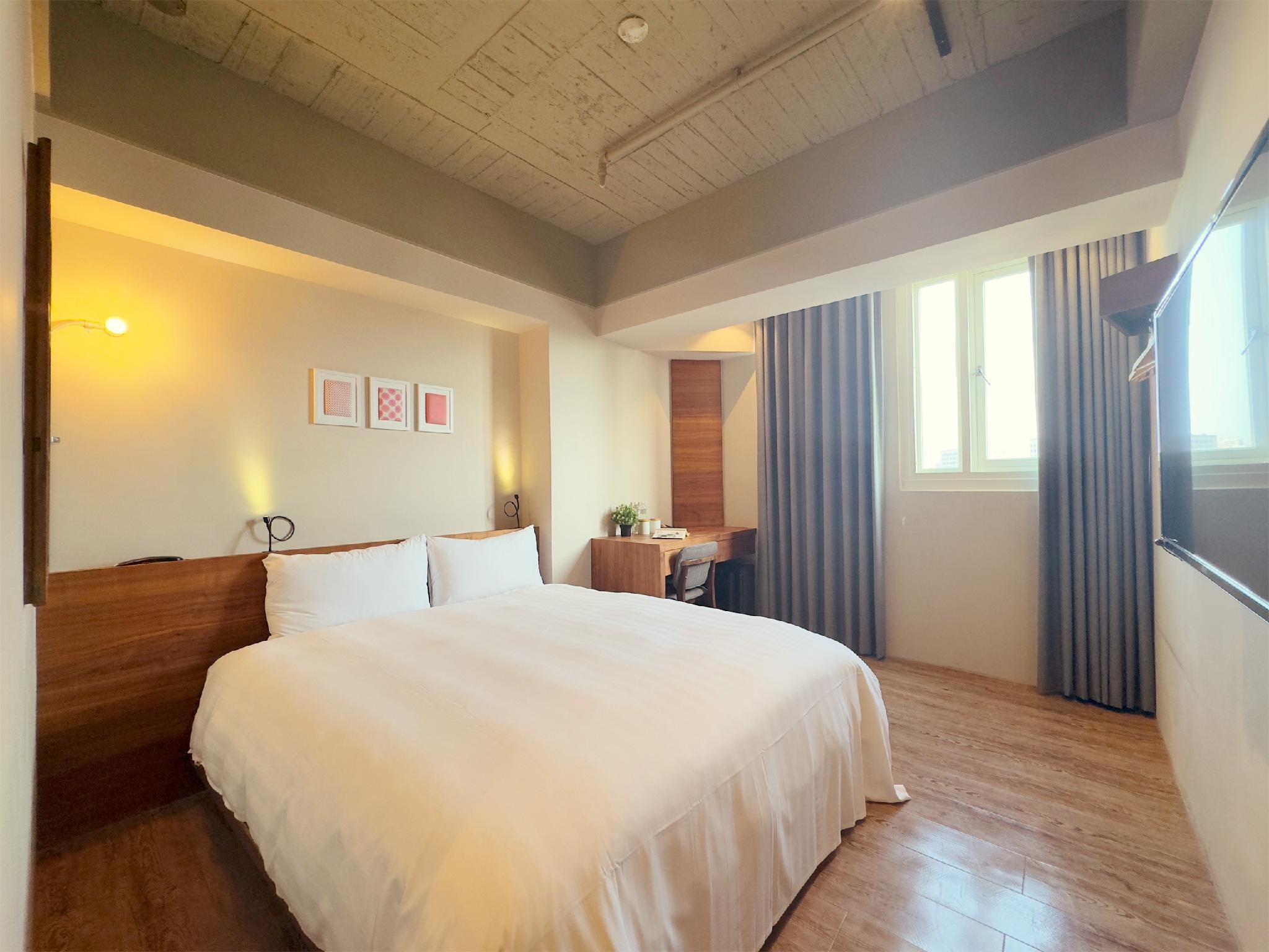 Roaders Hotel Tainan Chengda: Guestroom with a double bed, desk, curtains and window