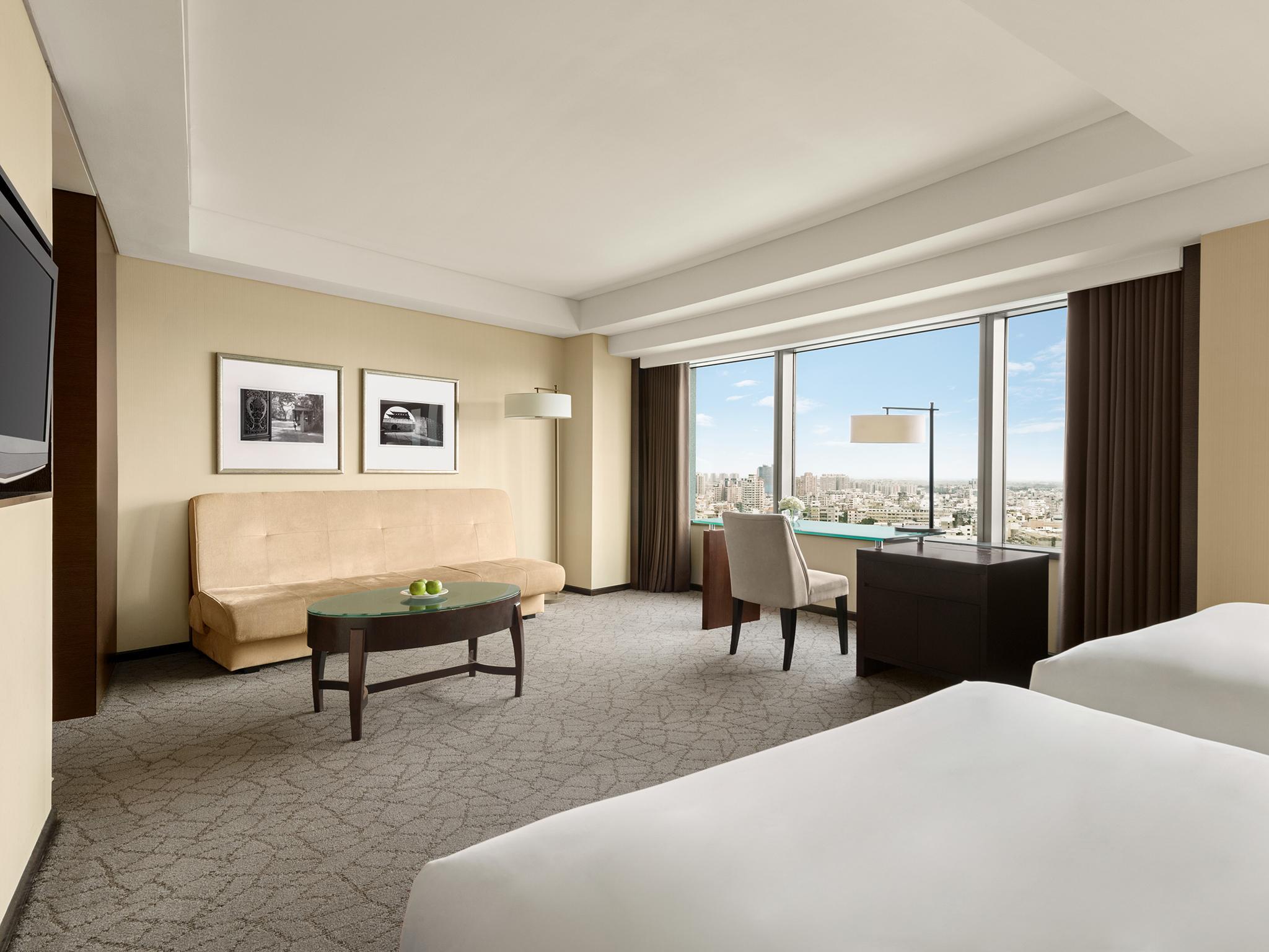 Shangri-La Far Eastern Tainan: Guestroom with part of the bed, a sofa and a window-side desk