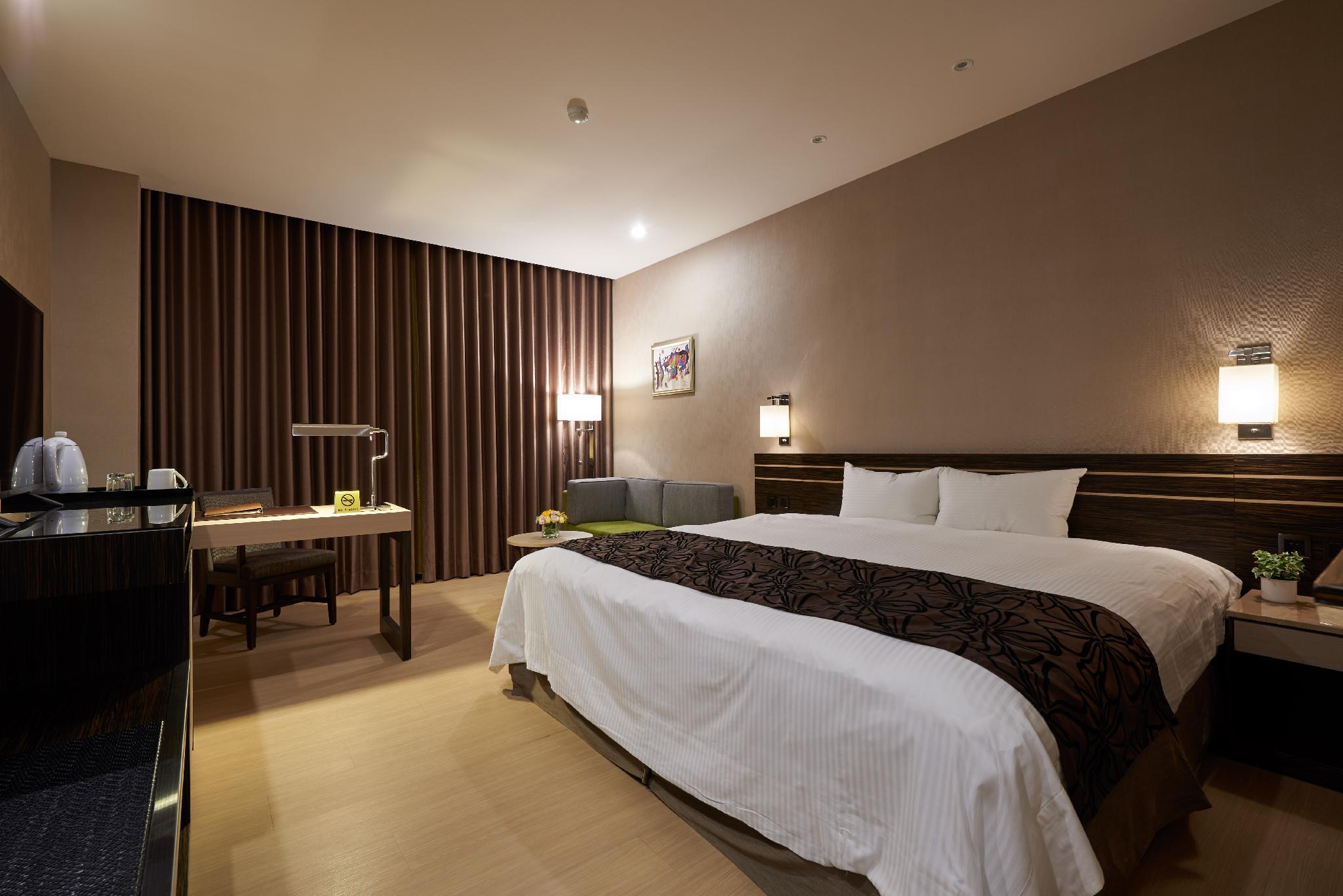 Sol Hotel: A room with a large bed, desk, sofa and curtained window