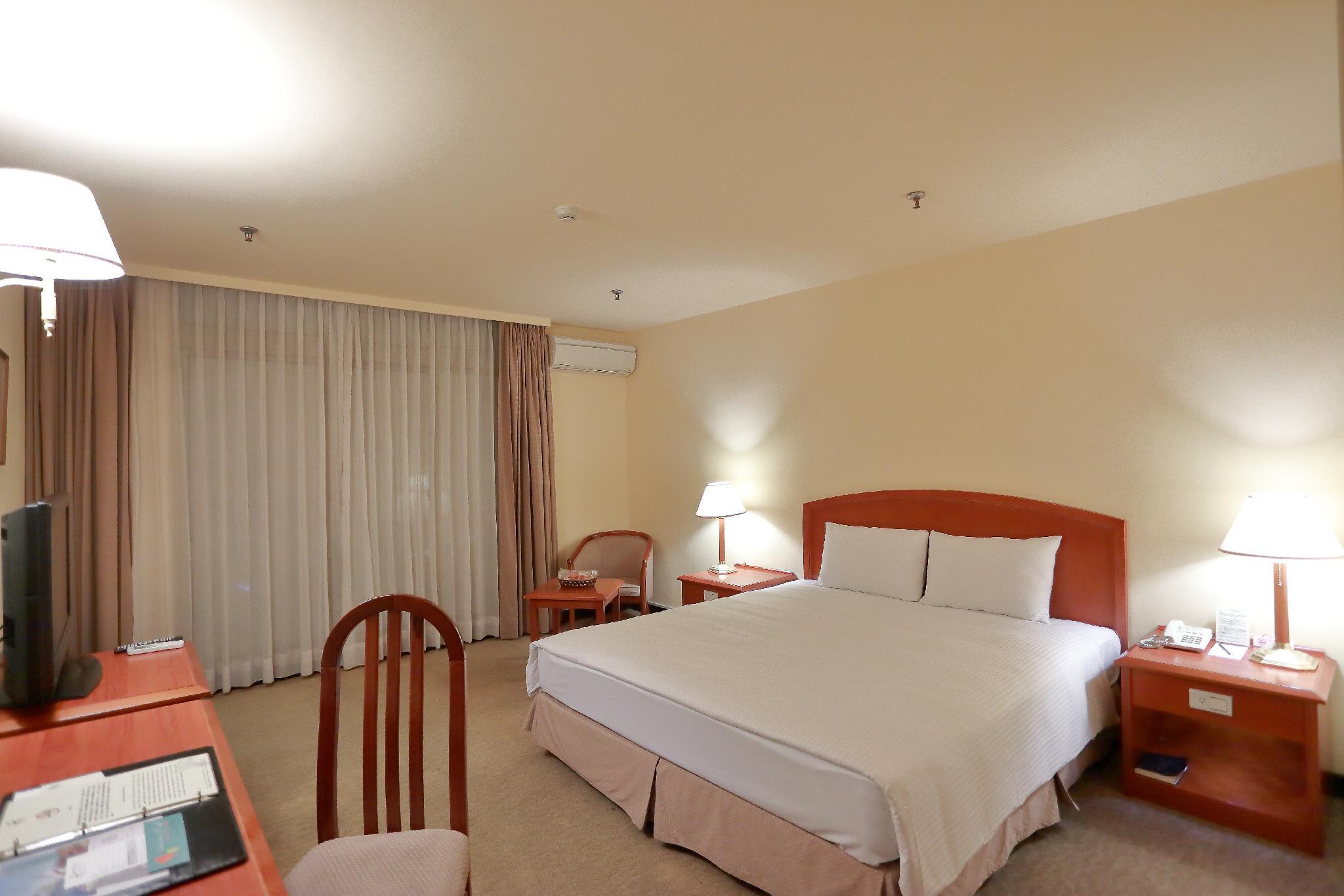 玖屋文旅 / Jiuwu Hotel: 침대·목재 가구와 커튼이 보이는 객실