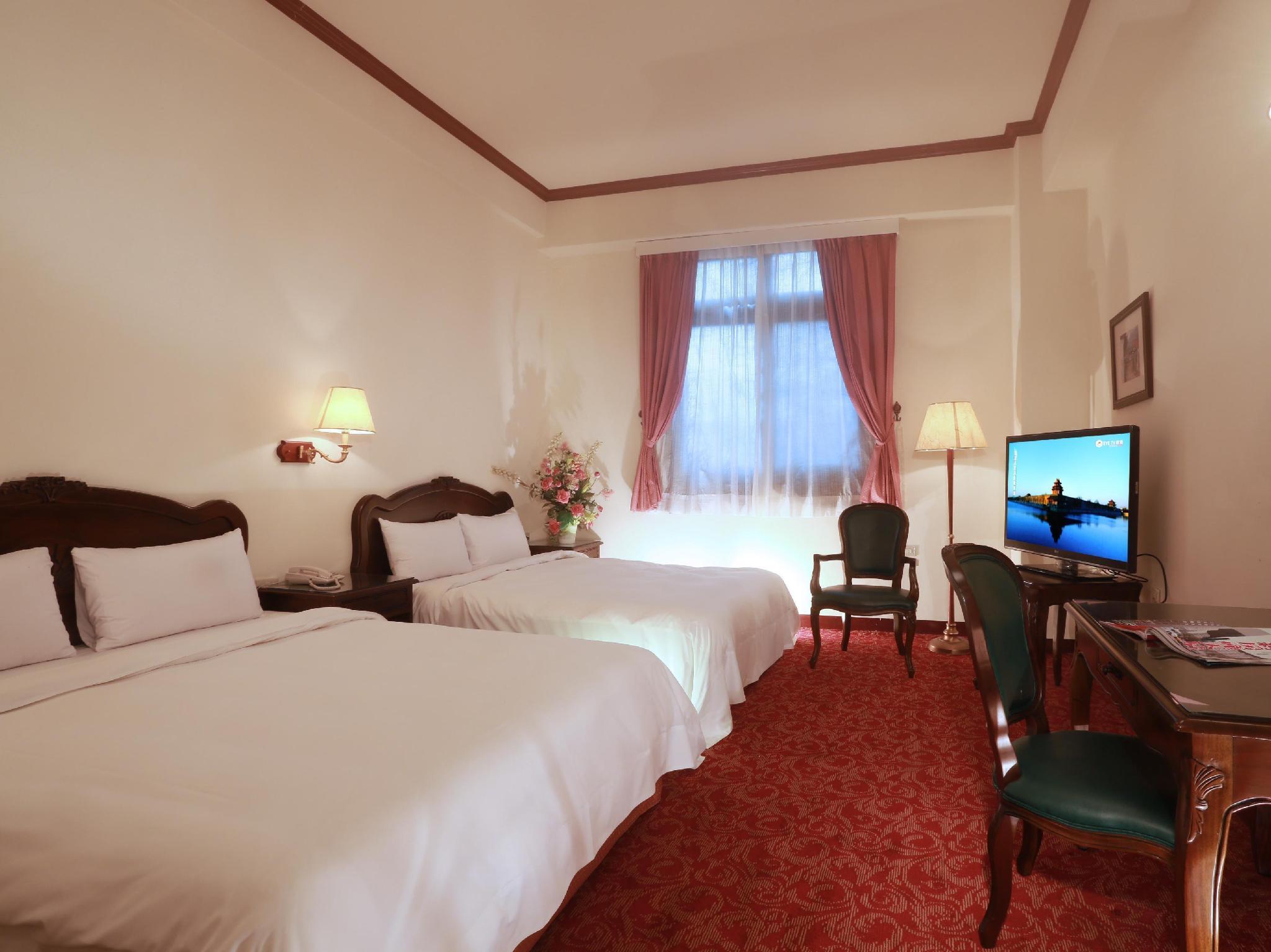 東方商務大飯店 / East Commercial Affairs Hotel: 두 침대·목재 헤드보드와 붉은 카펫이 보이는 객실
