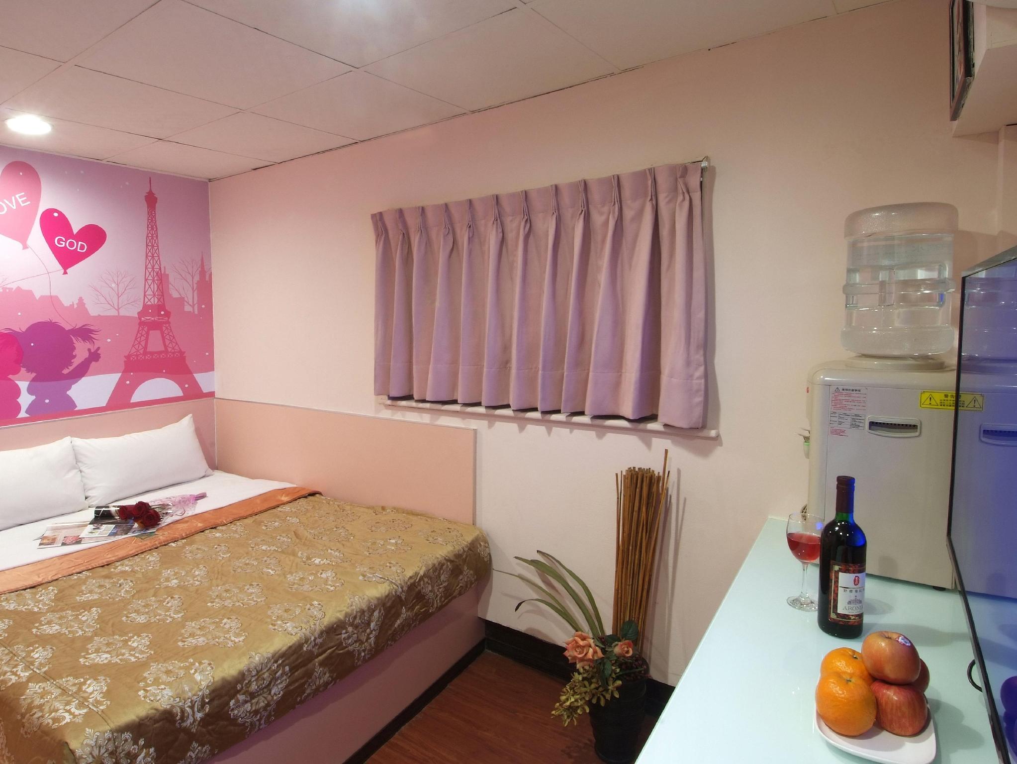 Tong Bing Express Inn Hotel: A room showing a large bed, curtains, desk and water dispenser