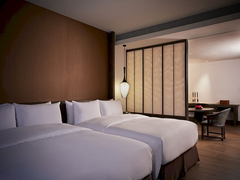 Silks Place Tainan: Guestroom with two beds, seating and a bathroom partition