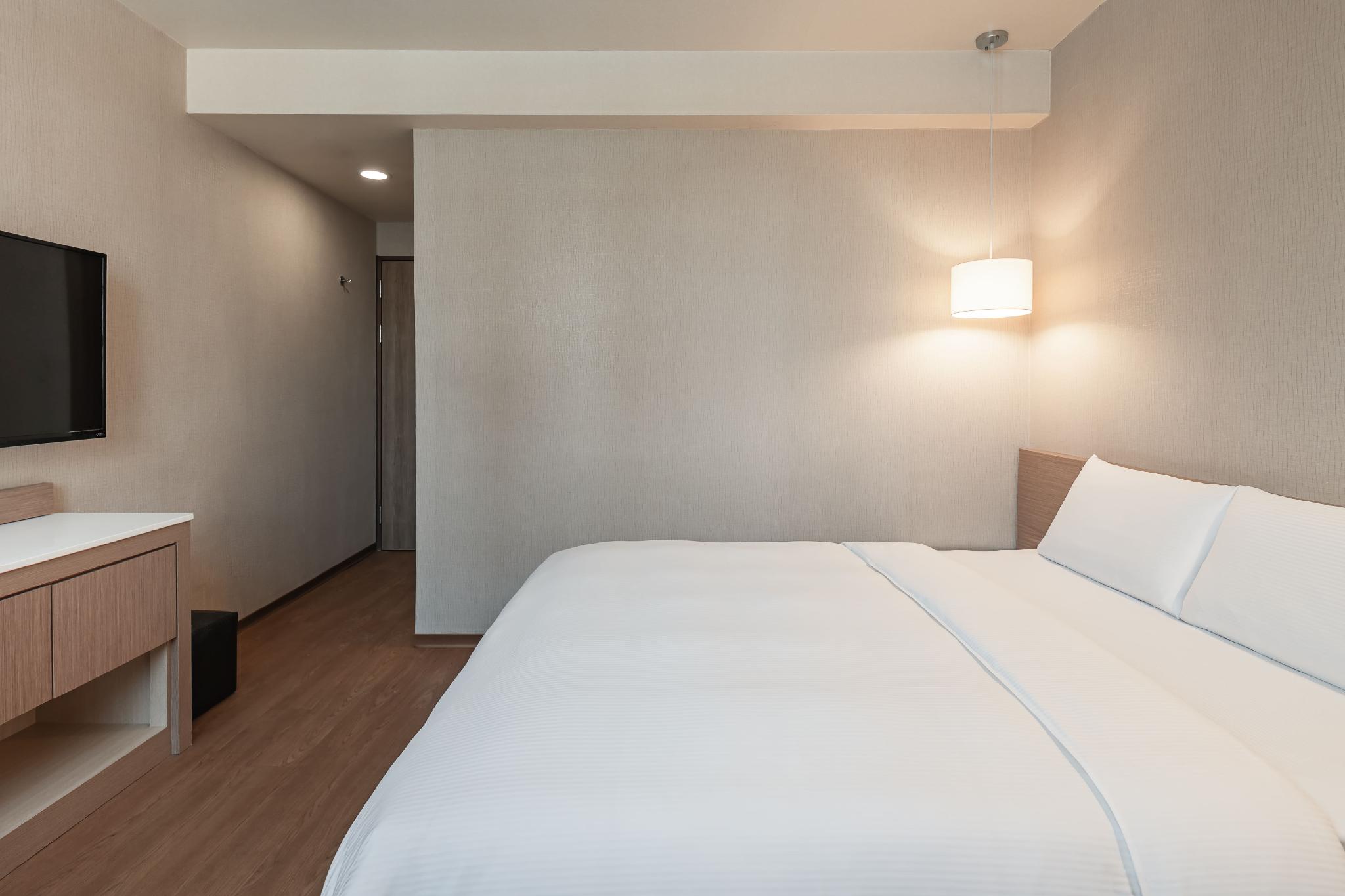 Kindness Hotel – Kaohsiung Main Station 공급사 객실 사진: 침대·TV·책상 수납·입구 통로