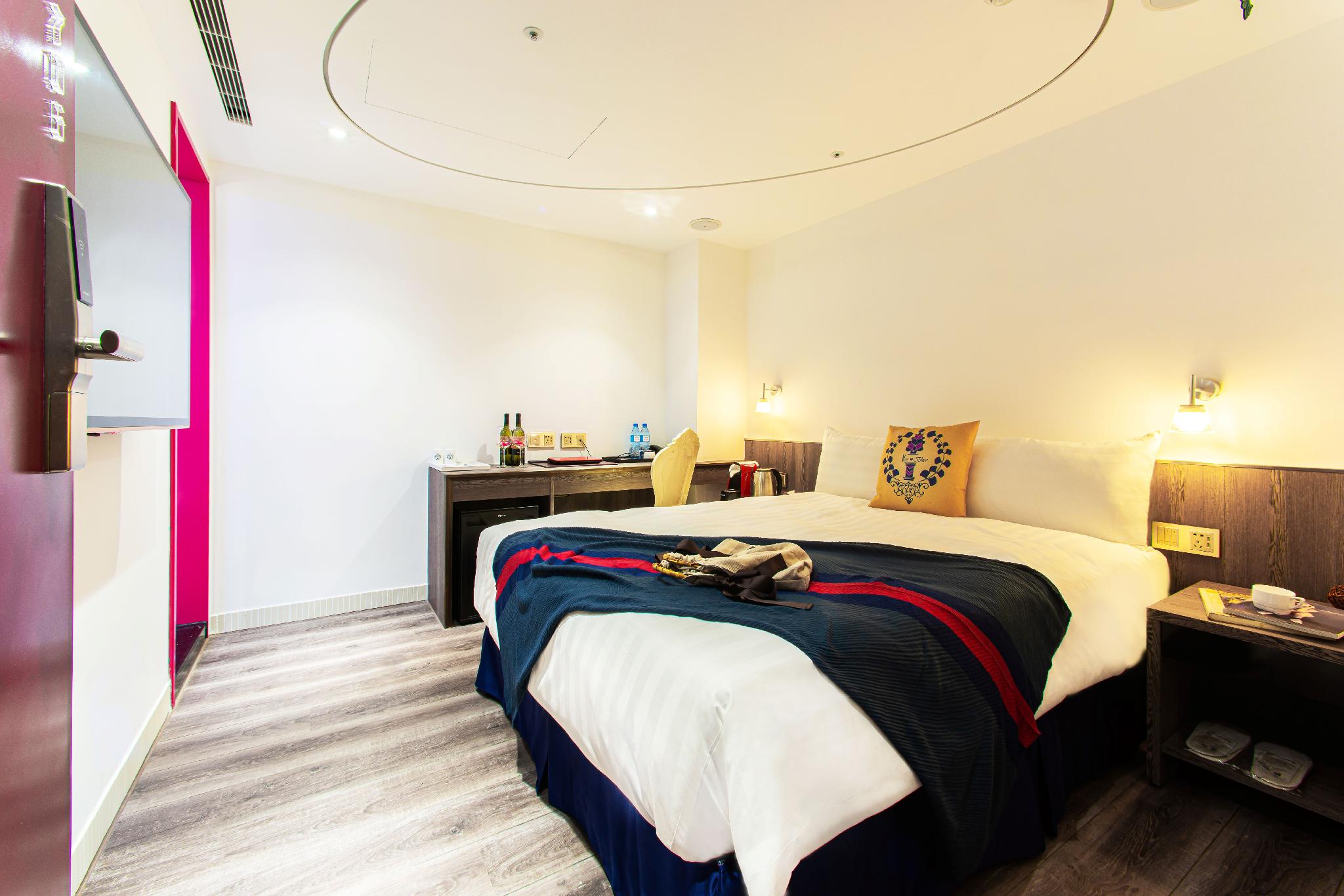 Norway Forest Travel Hotel 1 Taichung: 남색·빨간색 담요가 놓인 침대·책상·욕실 문이 보이는 객실