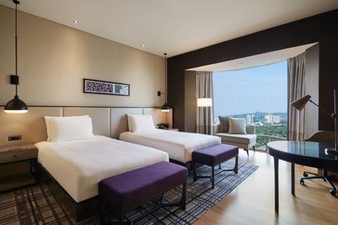 Hilton Kuala Lumpur: 두 침대·창문·좌석과 원형 테이블이 보이는 객실