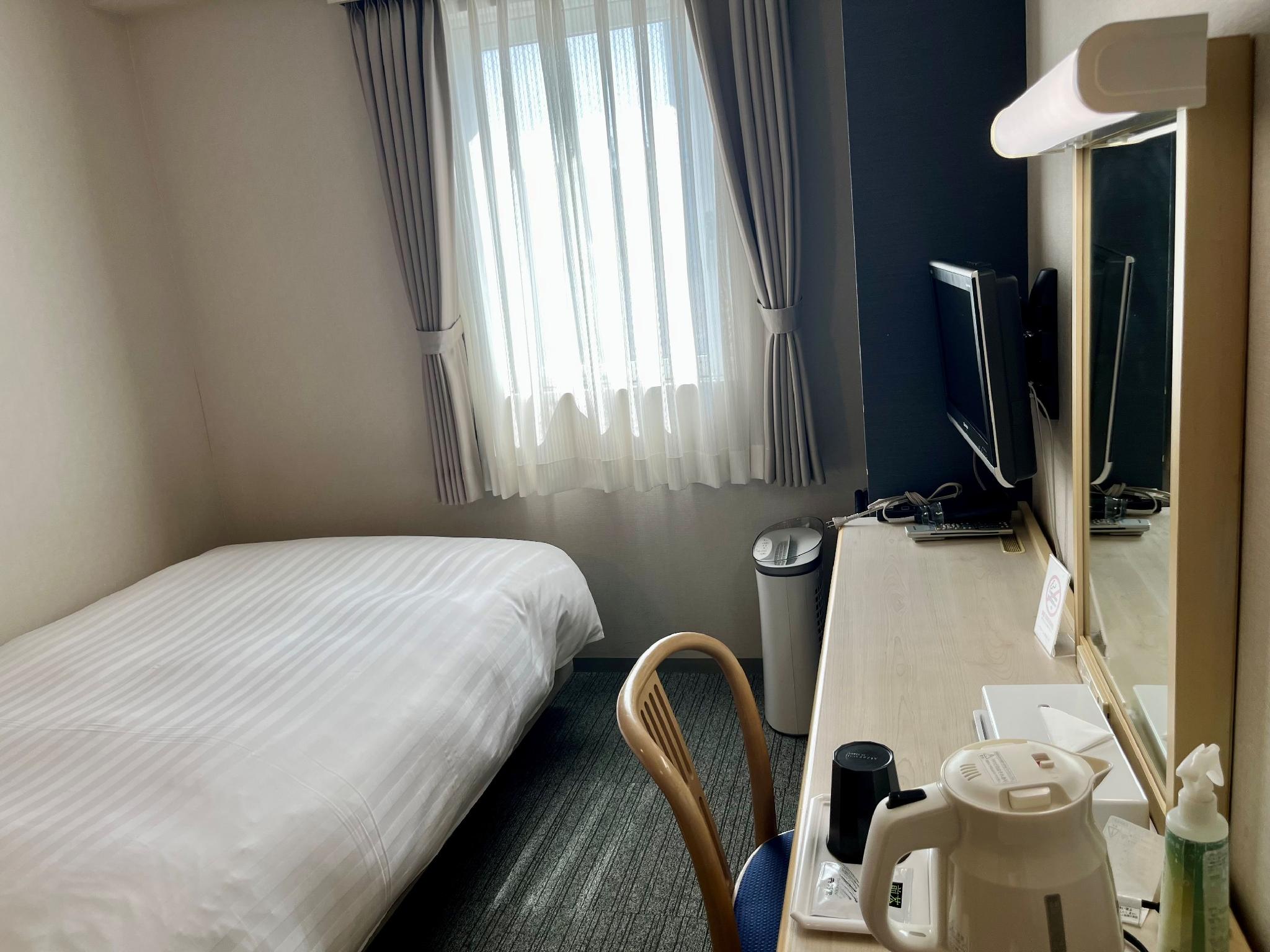 Hotel Premium Green Plus 침대1개·창문·책상·TV와 좁은 객실 통로