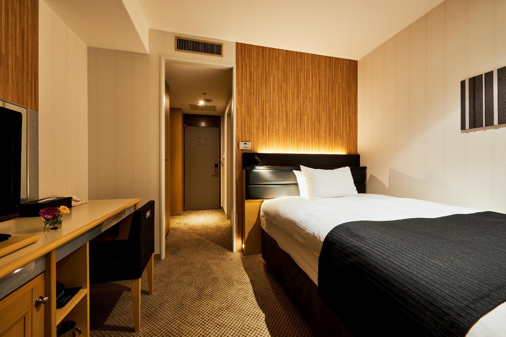 Sendai Kokusai Hotel 침대1개·책상·TV와 출입구 쪽 객실 공간